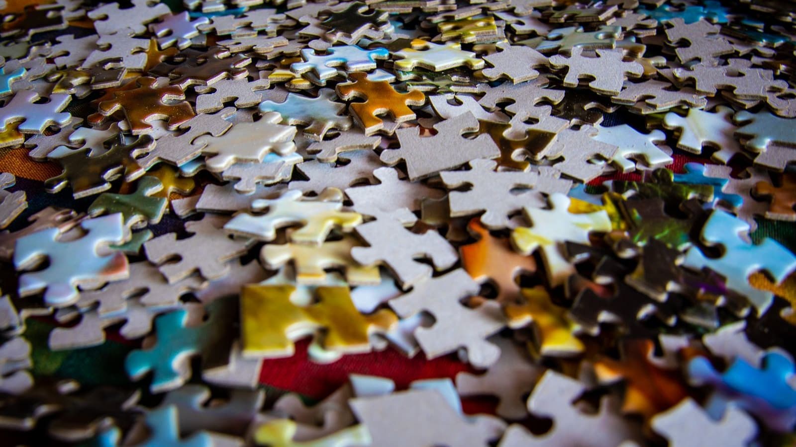 A large pile of jigsaw puzzle pieces waiting to be sorted