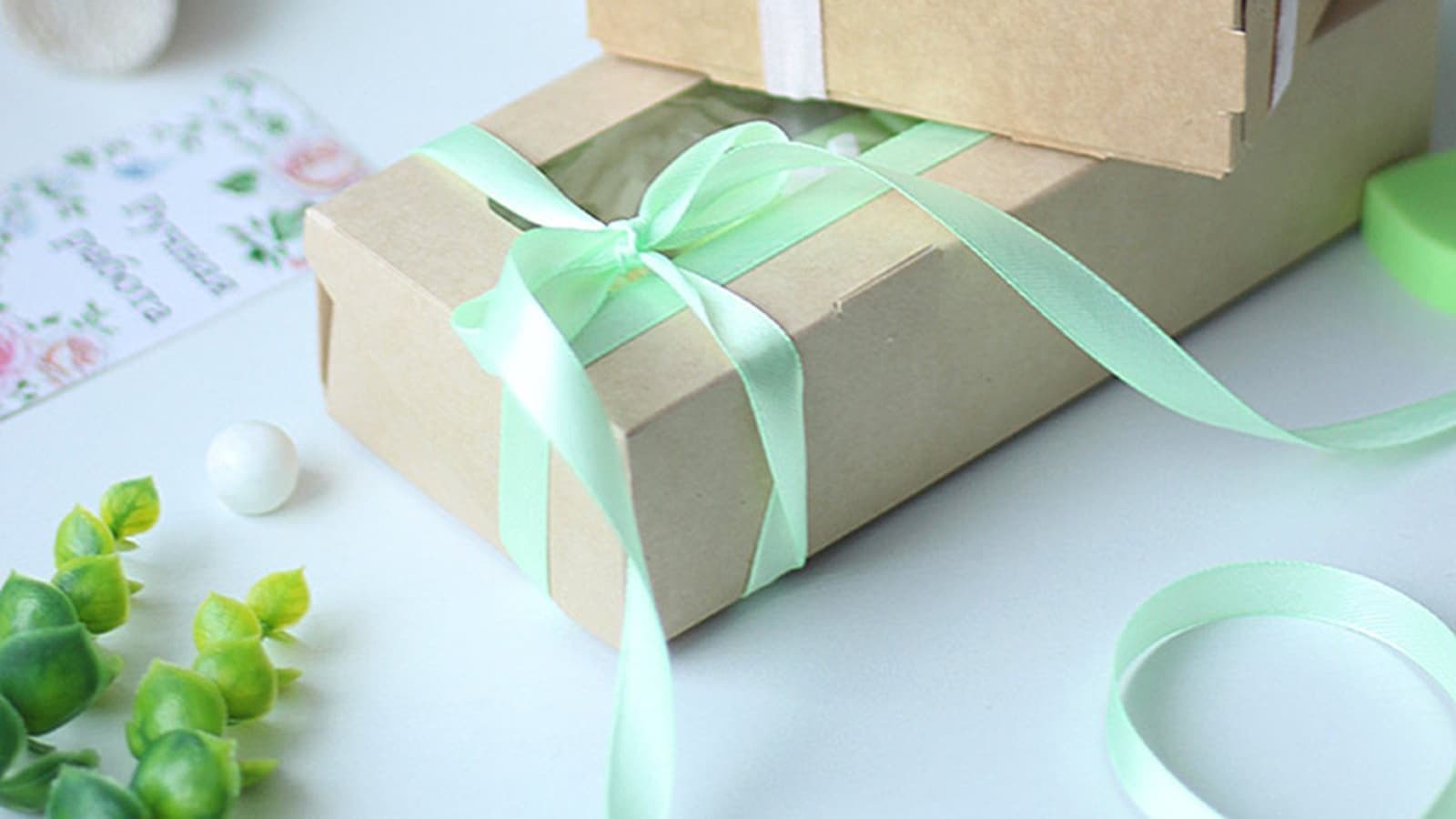 Gift boxes tied with pale ribbon on a white table