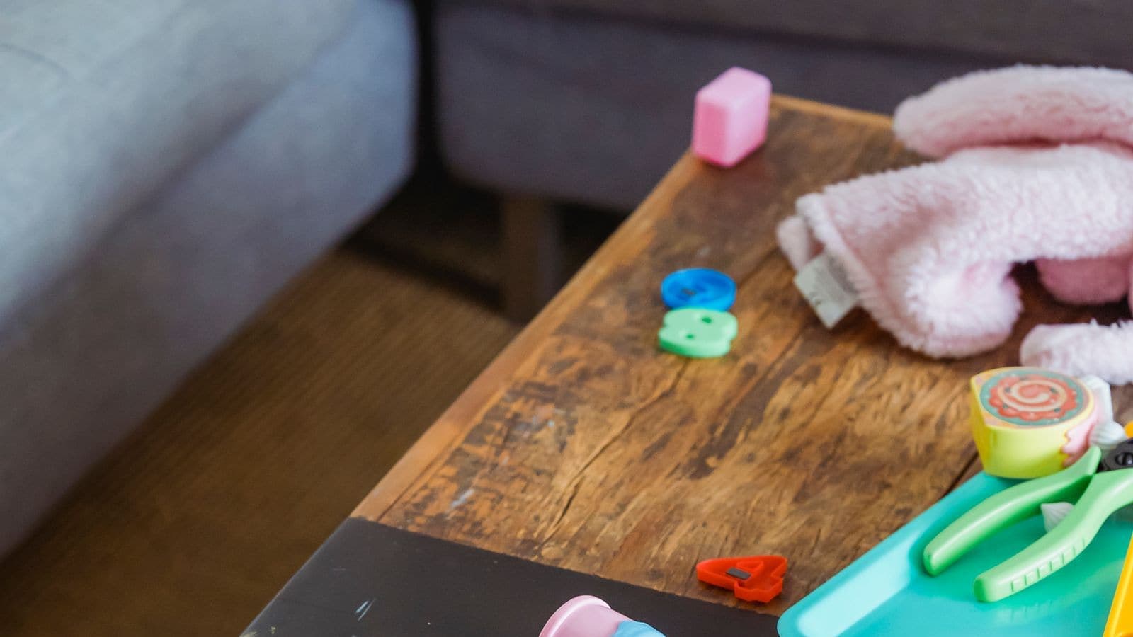 Small toys, letters and a toy motorbike scattered on a wooden table